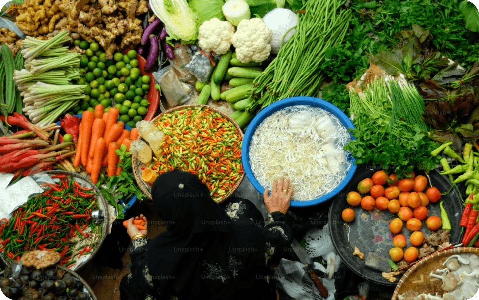 Pedagang menata sayuran segar di pasar tradisional.